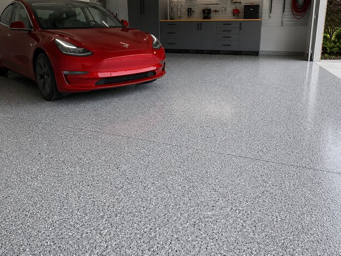 White electric car on a coated grey garage floor